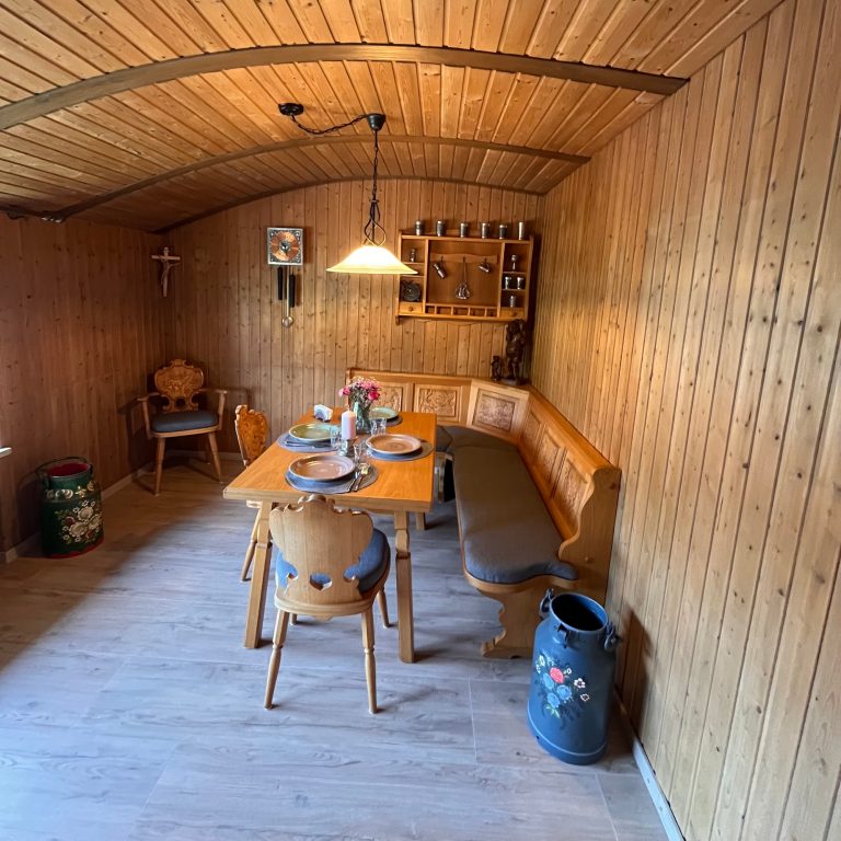 Casa Heckl Ferienwohnung Tutzing Traubing Starnberger See Gemütlicher Holzstuben-Essbereich mit Tisch, Bänken und rustikaler Einrichtung.