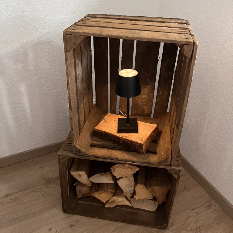 Rustikale Holzkiste mit Lampe und gestapeltem Holz als Deko. Rustikale Holzkiste mit Lampe und gestapeltem Holz als Deko.