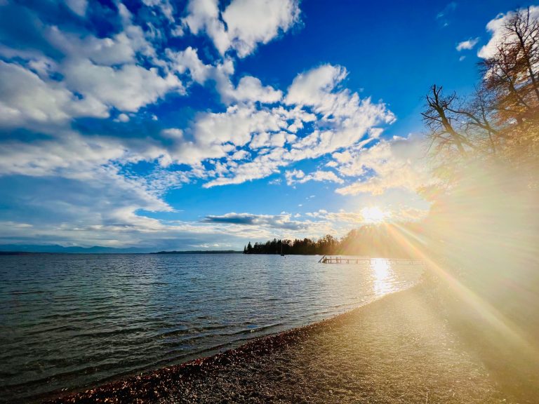 Tutzing Traubing Ferienwohnung Casa Heckl Sonnenuntergang am See mit Wolken und sanftem Licht am Horizont.
